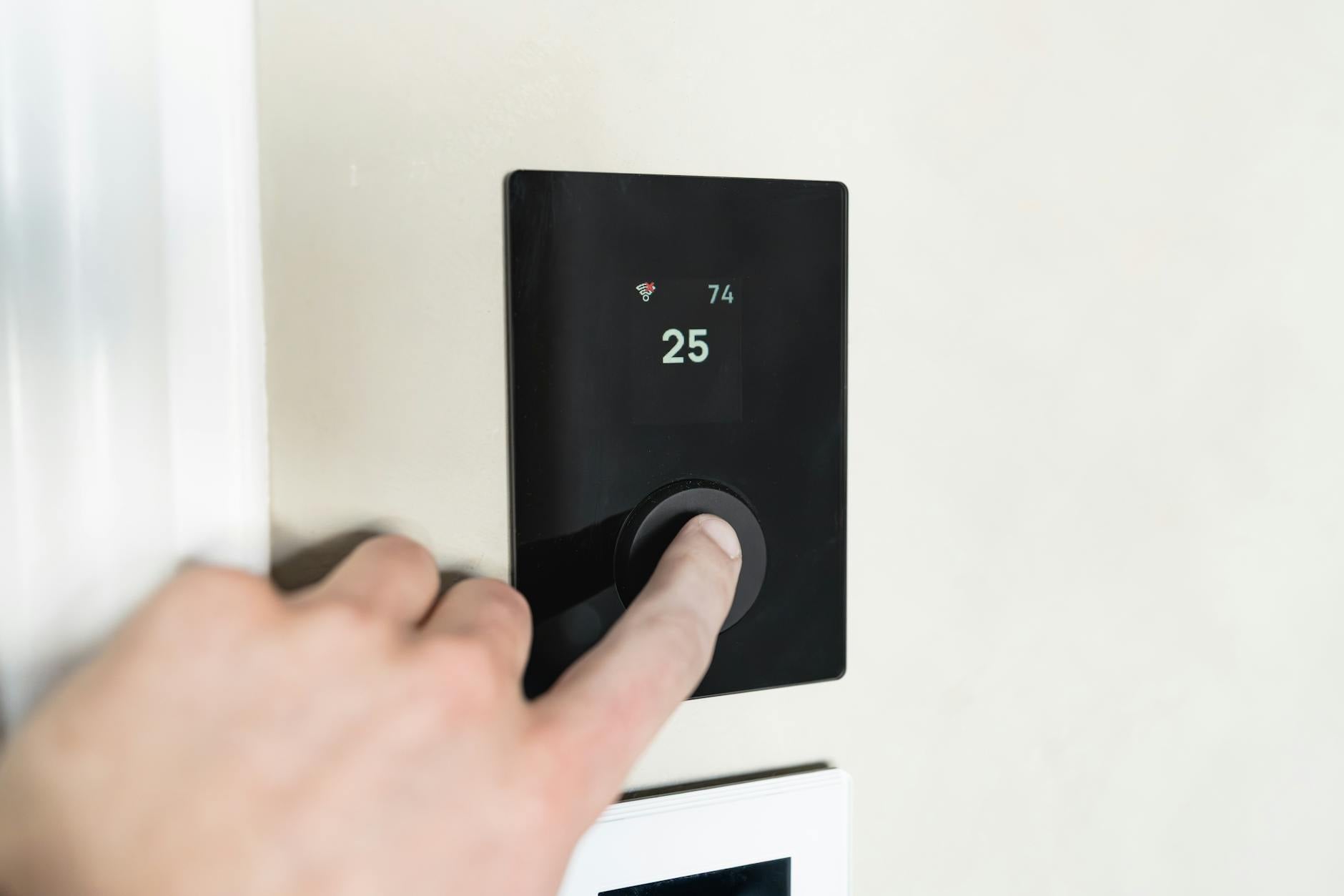 Homeowner adjusting a smart thermostat in a comfortable living room